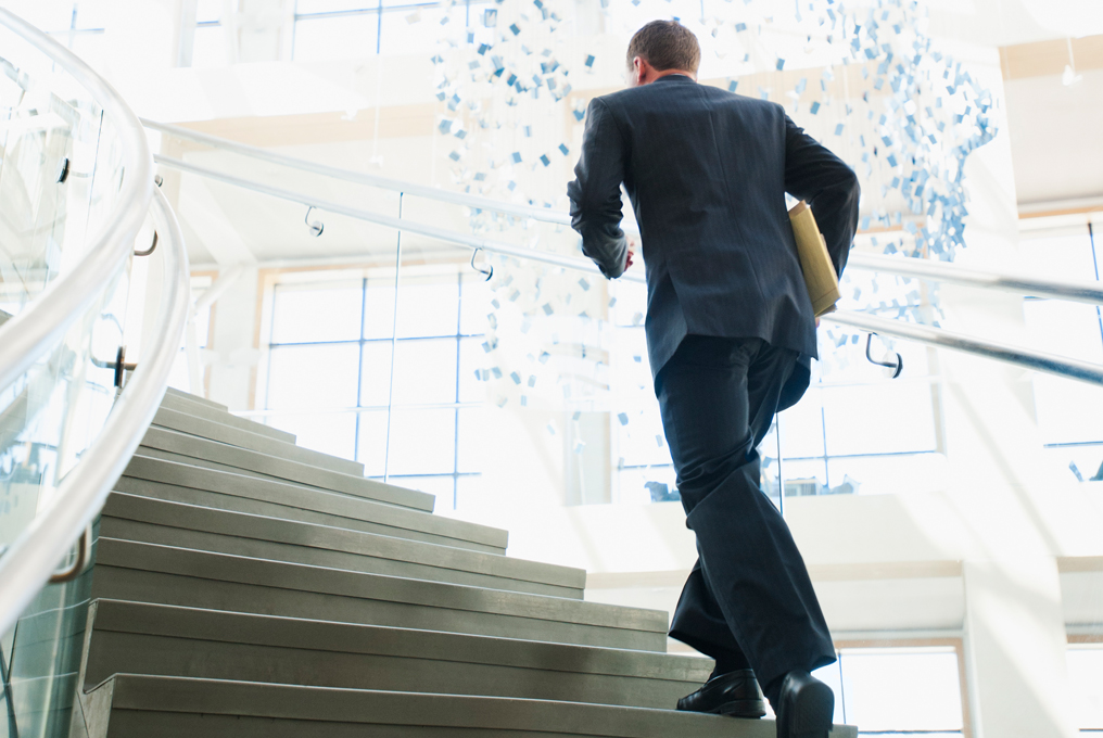 Ein Geschäftsmann rennt die Treppen hoch.