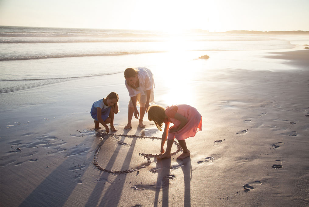 Una famiglia gioca con la sabbia al mare.