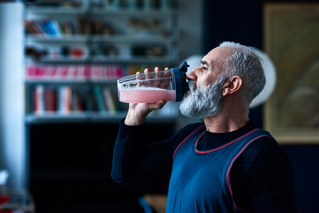 Un homme plus âgé boit un milk-shake.