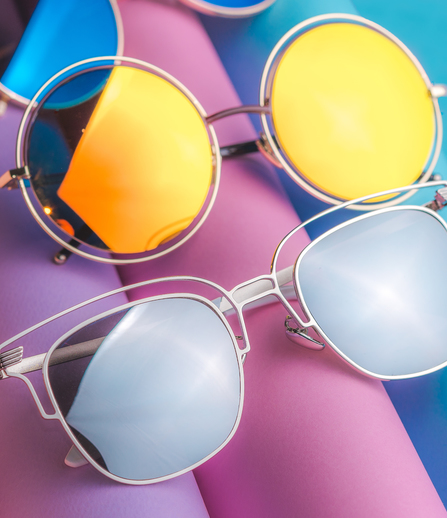 Diversi occhiali da sole su sfondo