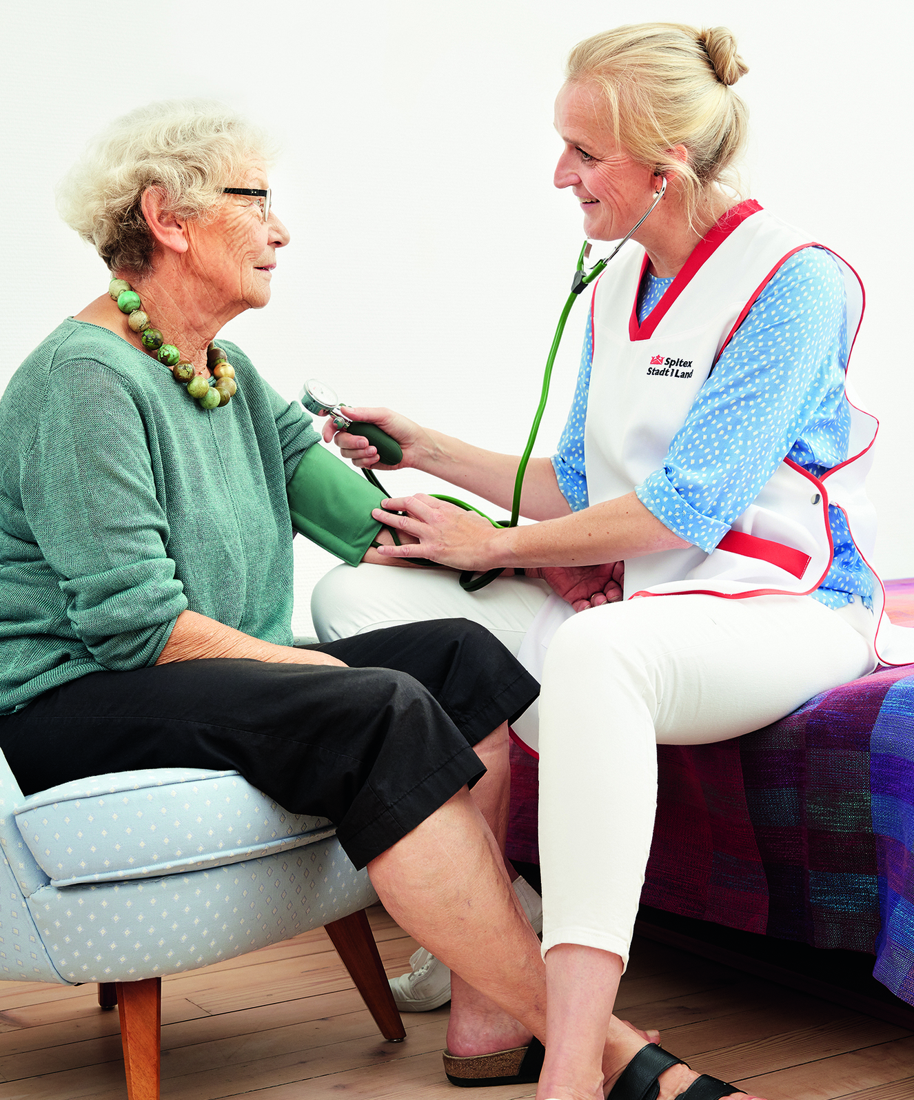 Spitex esamina la pressione sanguigna in una signora