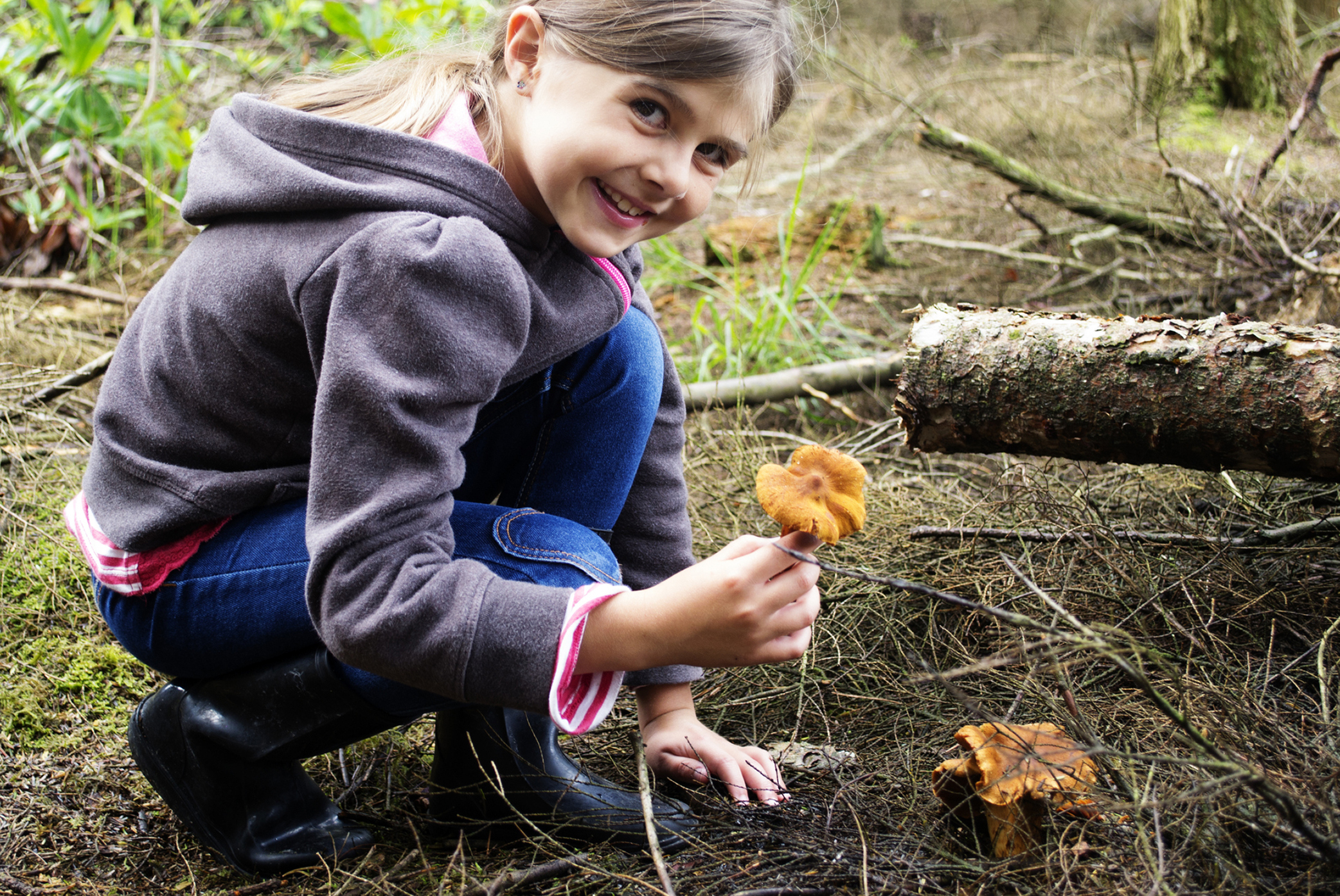Jeune fille dans la forêt avec un champignon à la main 