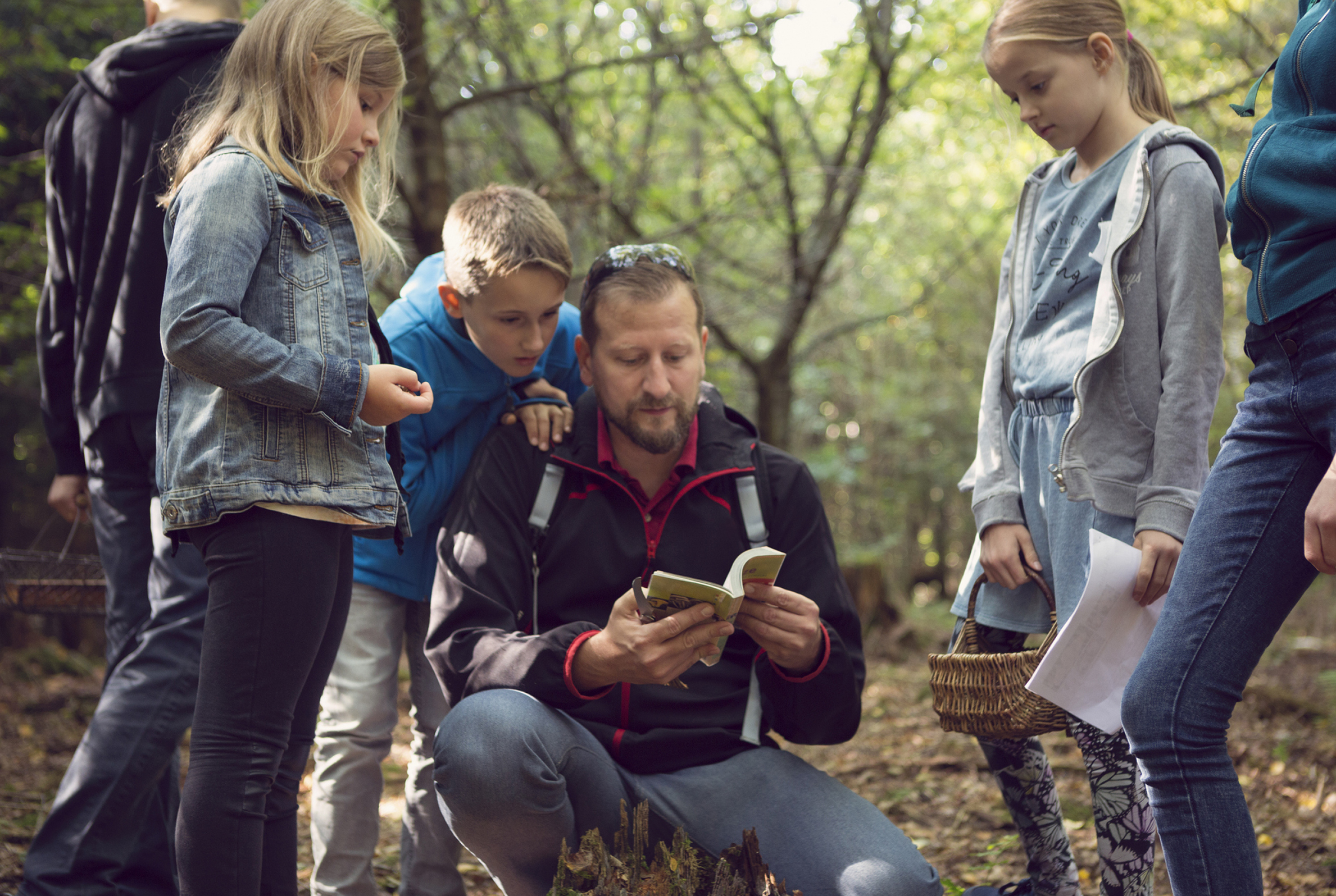 Famille avec livre sur les champignons