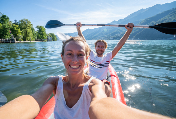 Kanutour in der Schweiz. Junges Paar fährt Kanu im Bergsee