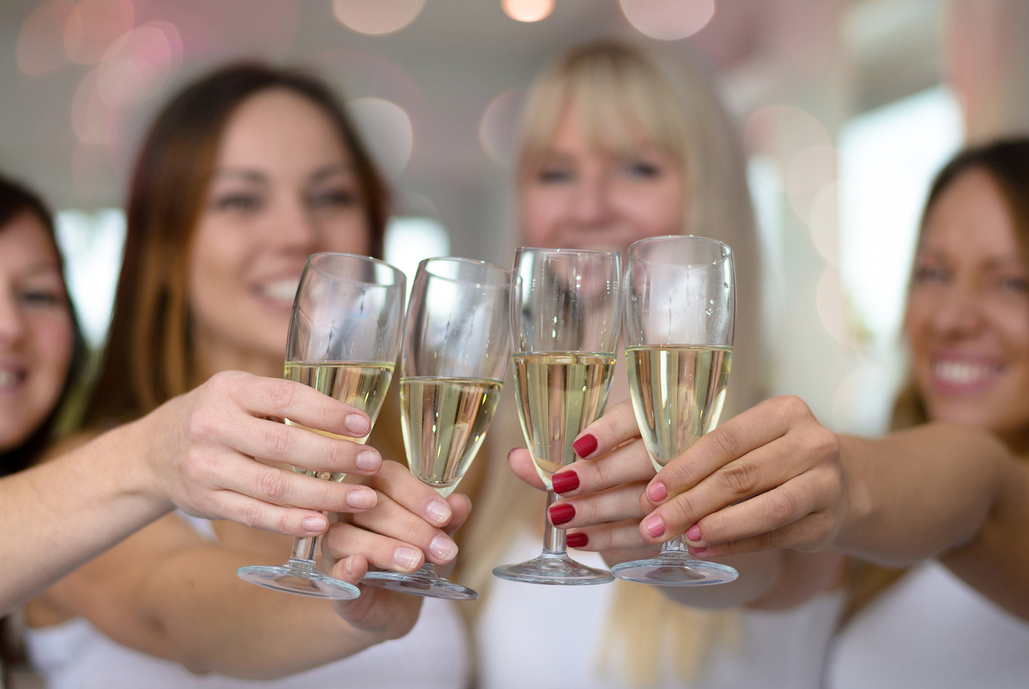 Prima del matrimonio: Quattro giovani donne che brindano con bicchieri di champagne